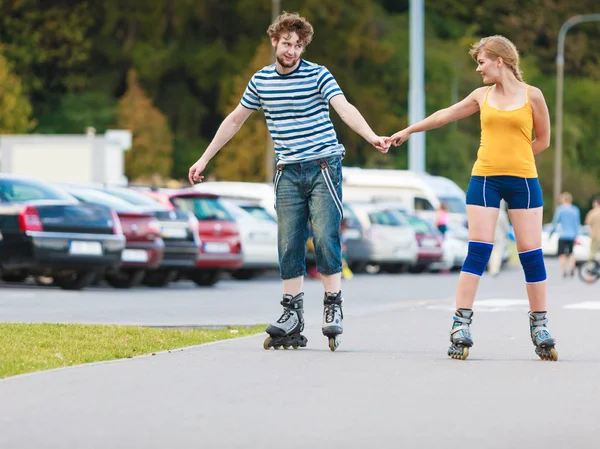 롤러스케이트를 타며 야외에서 노는 젊은 부부 — 스톡 사진