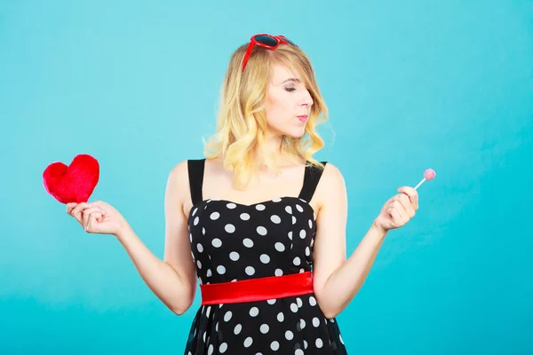 Mujer sostiene corazón rojo símbolo de amor y caramelo piruleta —  Fotos de Stock