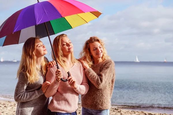 Tres mujeres bajo paraguas colorido — Foto de Stock