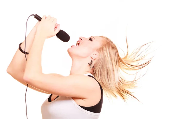 Blonde woman singing to microphone, profile view — Stock Photo, Image