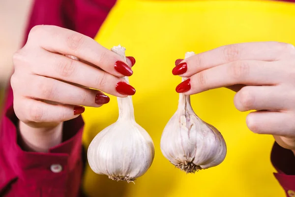 Woman holding two garlic — Stock Photo, Image