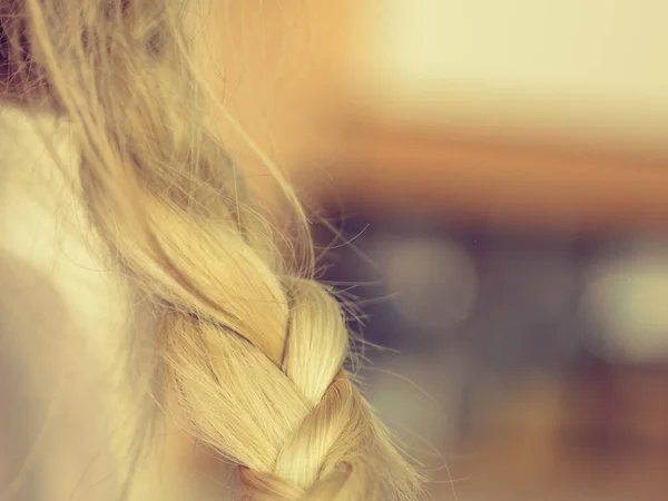 Жінка робить косу на світле волосся — стокове фото