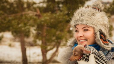 Küçük köpeğini kışın ısınma kadın kucaklama