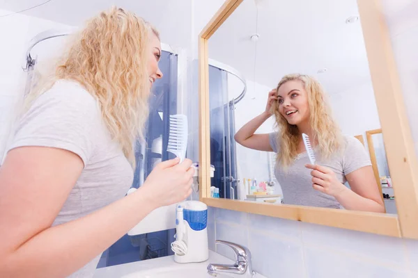 Donna spazzolando i suoi capelli biondi bagnati — Foto Stock