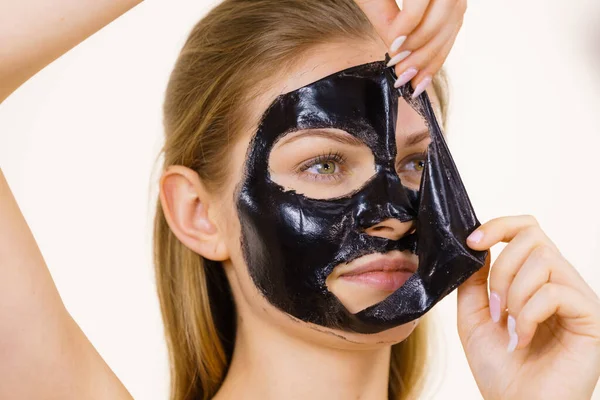 Flicka tar bort svart mask från ansiktet — Stockfoto