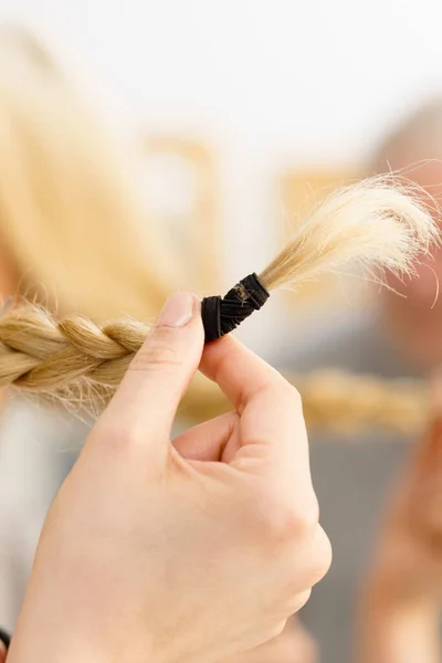 Donna che fa treccia sui capelli biondi — Foto Stock