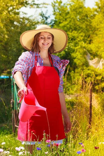 Mujer regando flores en el jardín — Foto de Stock