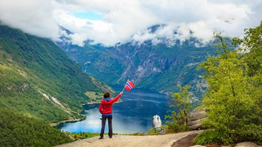 Norveç bayrağı turist Geirangerfjord üzerinde tutar