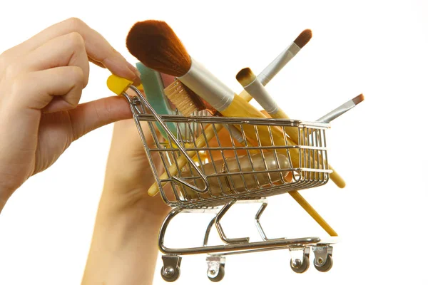 Woman holding shopping cart with make up brushes — Stock Photo, Image