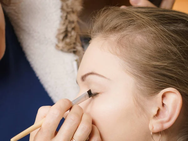 Mujer consiguiendo ojos maquillaje hecho por artista — Foto de Stock