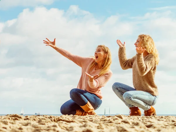 Женщины на пляже развлекаются, указывая пальцем — стоковое фото