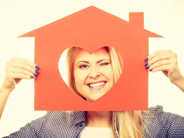 Rolig tjej håller rött papper hus med hjärta form — Stockfoto