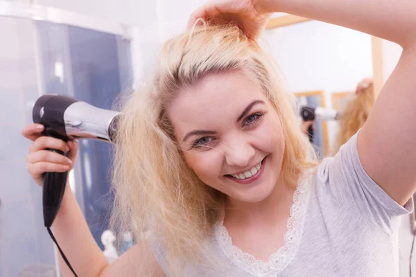 Frau trocknet Haare im Badezimmer — Stockfoto