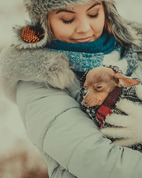 Γυναίκα αγκαλιά του πλανήτη το μικρό σκυλάκι της τον χειμώνα — Φωτογραφία Αρχείου