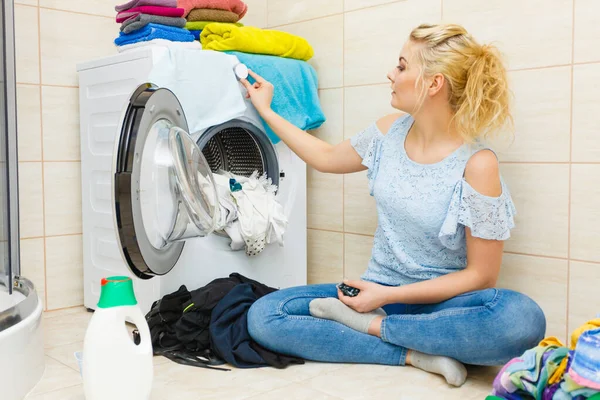 Woman wash laundry using detergent pods