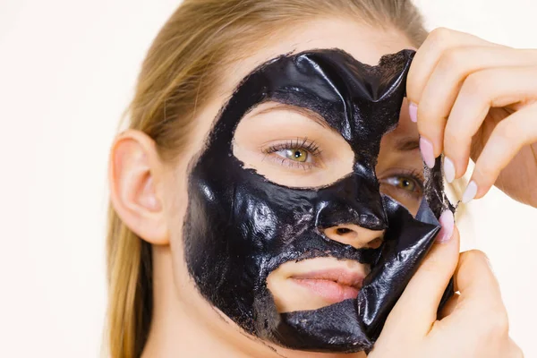 Chica quita la máscara negra de la cara — Foto de Stock