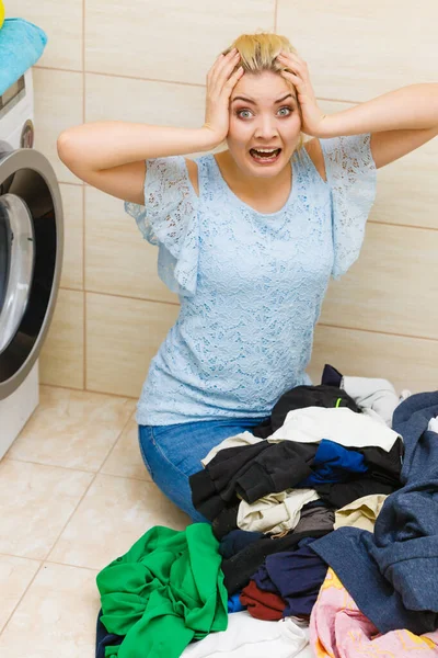 Unhappy girl sorting dirty clothes laundry.