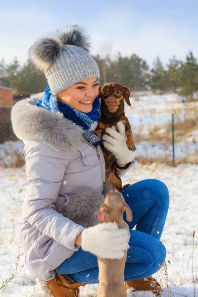 Mulher brincando com cães durante o inverno — Fotografia de Stock