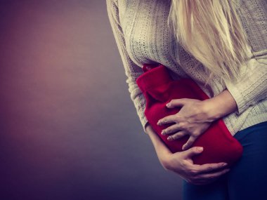 Holding sıcak su şişesi kadının duygu mide krampları