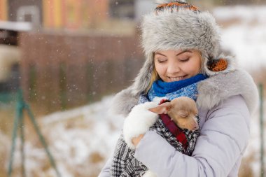 Küçük köpeğini kışın ısınma kadın kucaklama