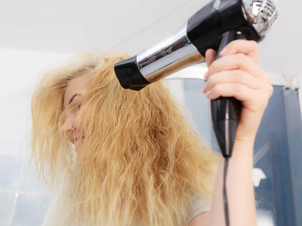 Mujer rubia usando secador de pelo — Foto de Stock