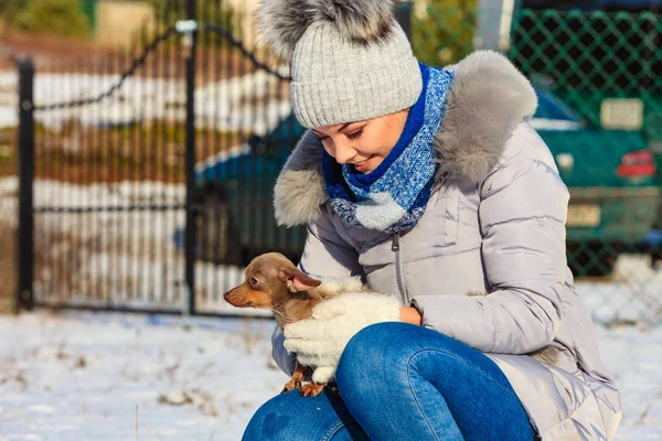 Mulher brincando com cão durante o inverno — Fotografia de Stock