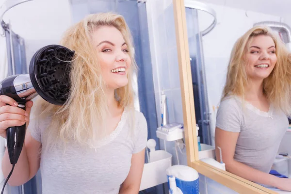 Женщина делает кудряшки с диффузором для волос — стоковое фото