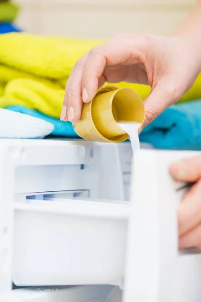 Человек заливки Умягчитель ткани в стиральную машину — стоковое фото