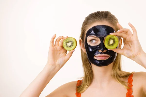 Girl black mask on face holds kiwi fruit — Stock Photo, Image