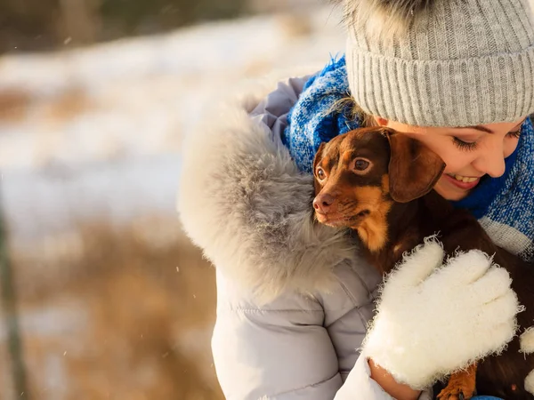 Mujer jugando con perro durante el invierno —  Fotos de Stock