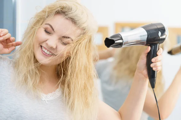 Blondine benutzt Haartrockner — Stockfoto