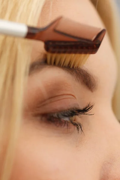 Mujer cepillándose las cejas — Foto de Stock