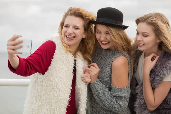 Três mulheres tomando selfie ao ar livre — Fotografia de Stock