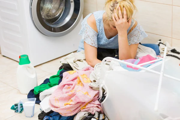 Unhappy girl sorting dirty clothes laundry.