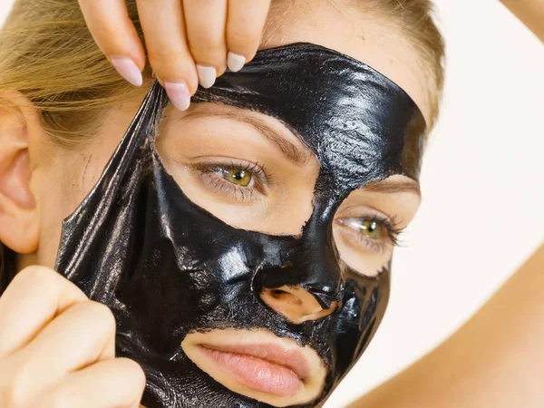 Chica quita la máscara negra de la cara — Foto de Stock