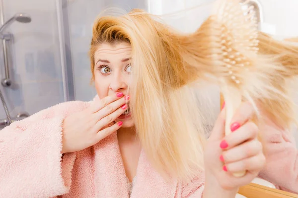 Σοκαρισμένος γυναίκα που φοράει ρόμπα βούρτσισμα τα μαλλιά της — Φωτογραφία Αρχείου