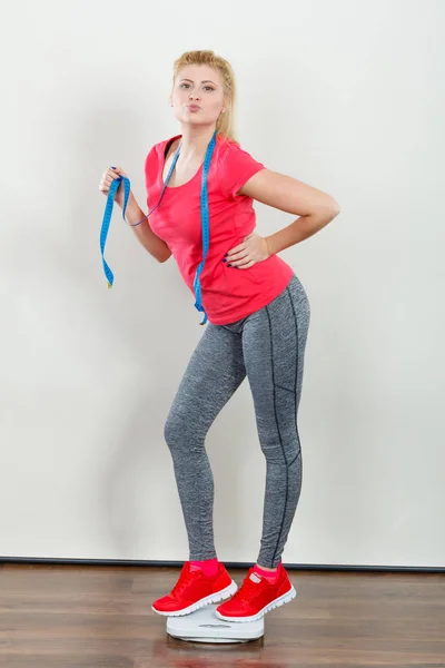 Woman wearing sportswear standing on weight machine — Stock Photo, Image