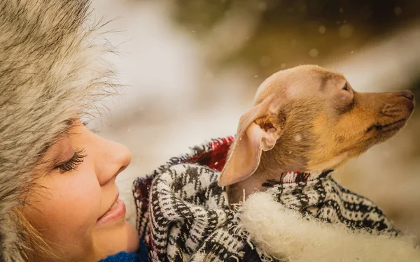 Mujer abrazo calentando su pequeño perro en invierno —  Fotos de Stock