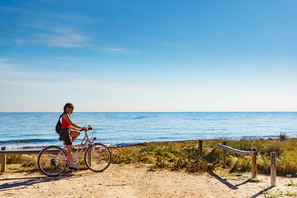 Femme vélo sur la plage, mode de vie actif . — Photo