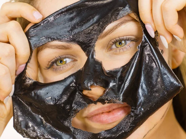 Девушка снимает черную маску с лица — стоковое фото