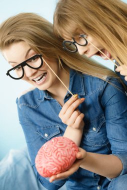 Dostluk, insan ilişkileri kavramı. İki deli kadın arkadaşlar veya kot gömlek ve gözlük sopa üzerinde giyen kız sorun holding sahte beyin çözme hakkında düşünme