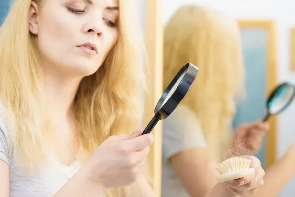 Женщина Использующая Увеличительное Стекло Смотрит Свою Кисть Изучение Выпадения Волос — стоковое фото