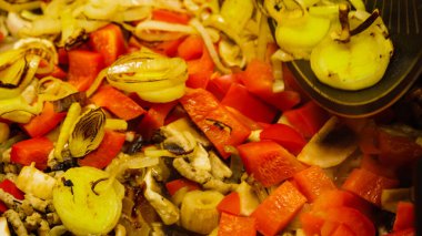 Lezzetli yemek hazırlıyorum. Karışık sebzelerle sıcak tavaya taze kızarmış soğan ekliyorum..