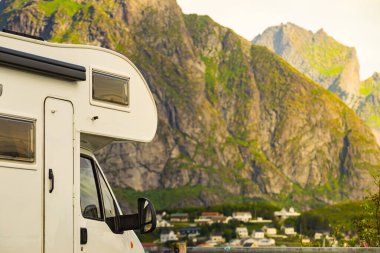 Yaz mevsiminde Reine köyü, Lofoten Norveç 'te karavan evi ve fiyort manzarası. Doğada kamp yapmak. Tatiller ve karavanla seyahat.