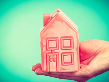 İlk düz daire. İleri adım konsepti. Erkek el ele tutuşmuş küçük kırmızı bir ev. Büyüme fikri olan yarı vücut adam..