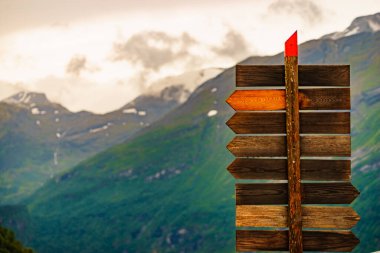 Turizm tatili ve seyahat. Norveç dağlarındaki tahta tabela direği. Yağmurlu bulutlu hava.
