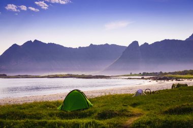 Yazın deniz kıyısında çadır. Okyanus kıyısında kamp yapmak. Lofoten takımadaları Norveç. Tatil ve seyahat.