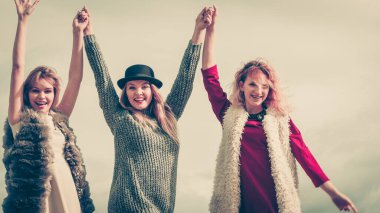 Üç modaya uygun kadın şık kıyafetler giyiyorlar. Tarz, moda, arkadaşlık konsepti.