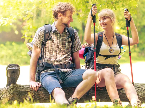 夏の時間を楽しんでします 林道上のバックパックと若いカップルのハイキング — ストック写真