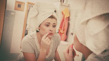 Yansıması hakkında ciddi bir yüz ifadesi, sahip onun kompleksleri ayna düşüncesinde bakarak kadın yüz cilt cilt analizi.